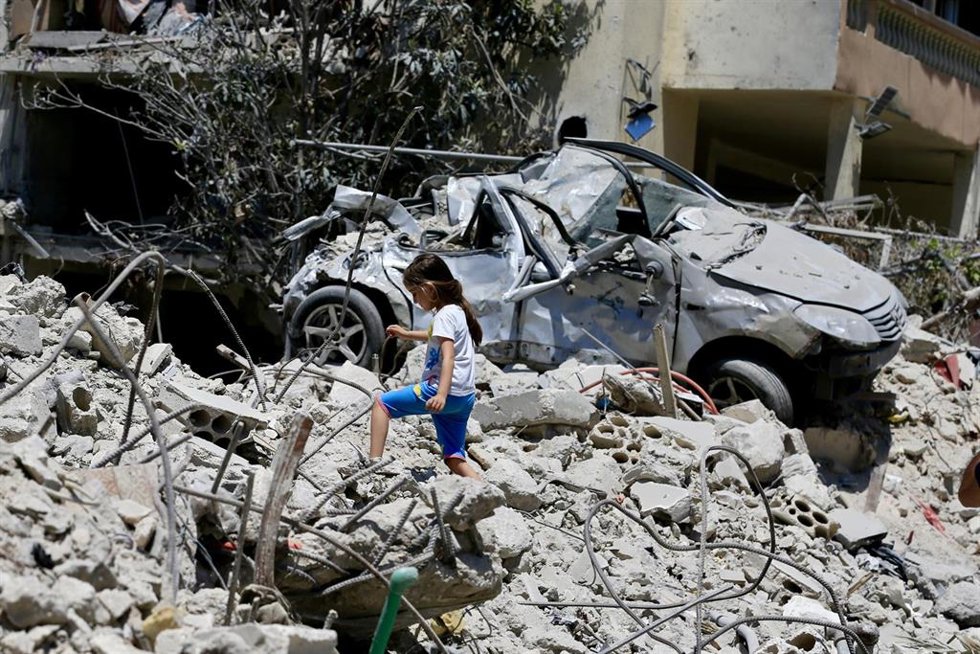 Archivo - Una niña inspeccionando edificios destruidos en Deir Qanoun En Nahr, en el sur de Líbano
