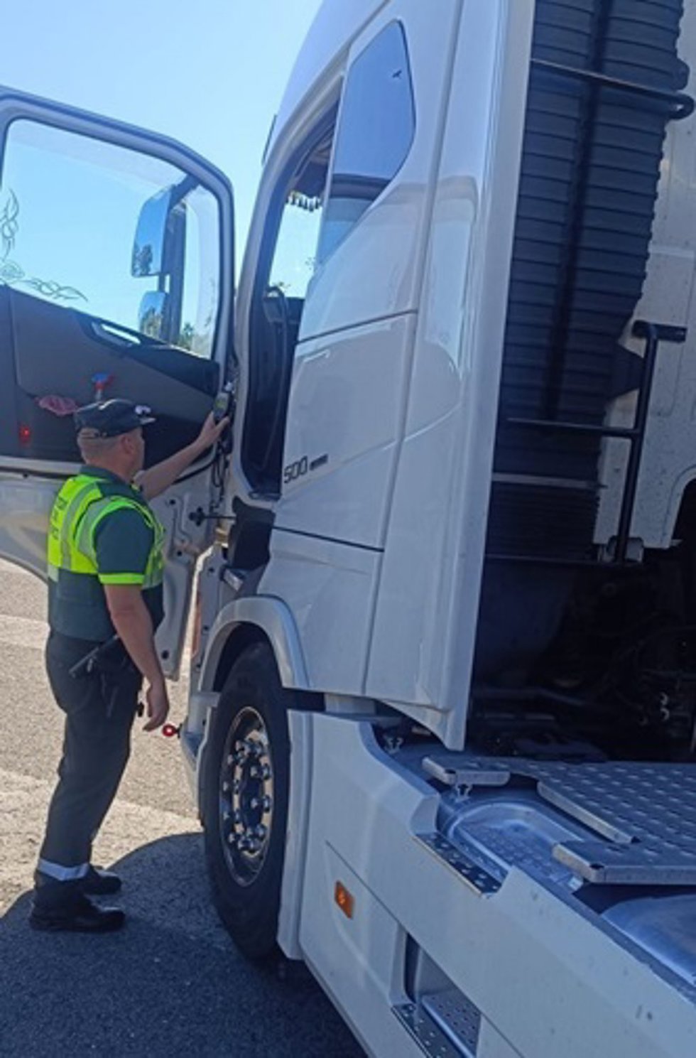 Un agente de la Guardia Civil realiza la prueba de alcoholemia al conductor del camión.