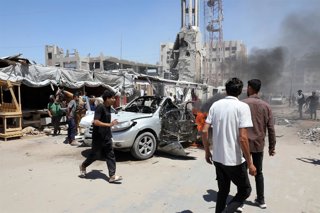 June 18, 2026, Gaza, Gaza Strip, Palestinian Territory: Palestinians and Civil Defense personnel gather around a destroyed vehicle that was targeted in an Israeli airstrike in Gaza City, on June 18, 2026. The strike killed three Palestinians, according to
