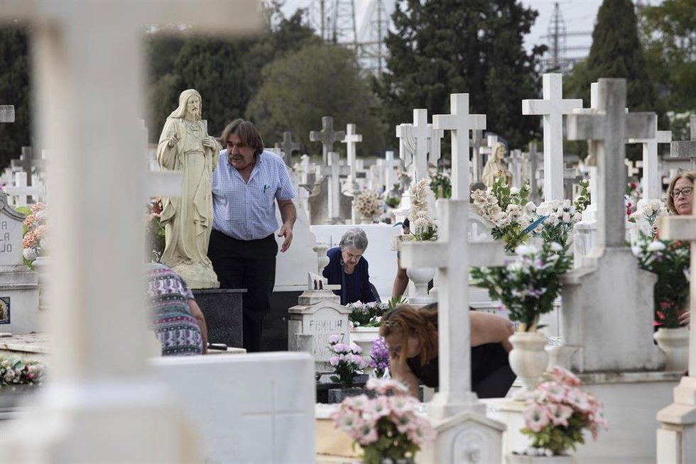 Archivo - Varias personas arreglando unas sepulturas en el cementerio sevillano en imagen de archivo. 