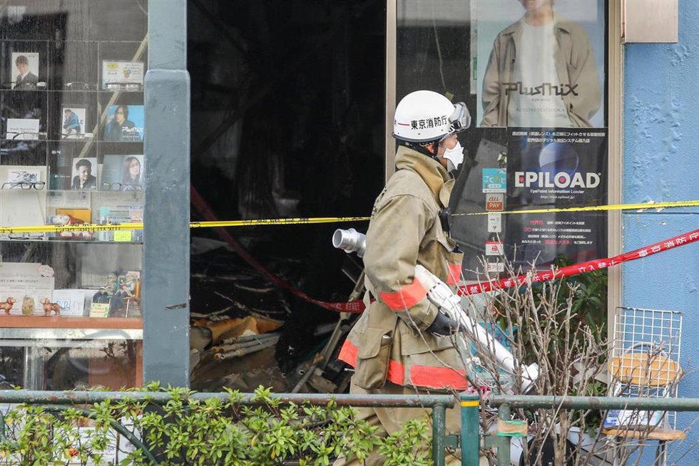Archivo - Un bombero pasa junto a una casa dañada en el distrito de Kōtō.