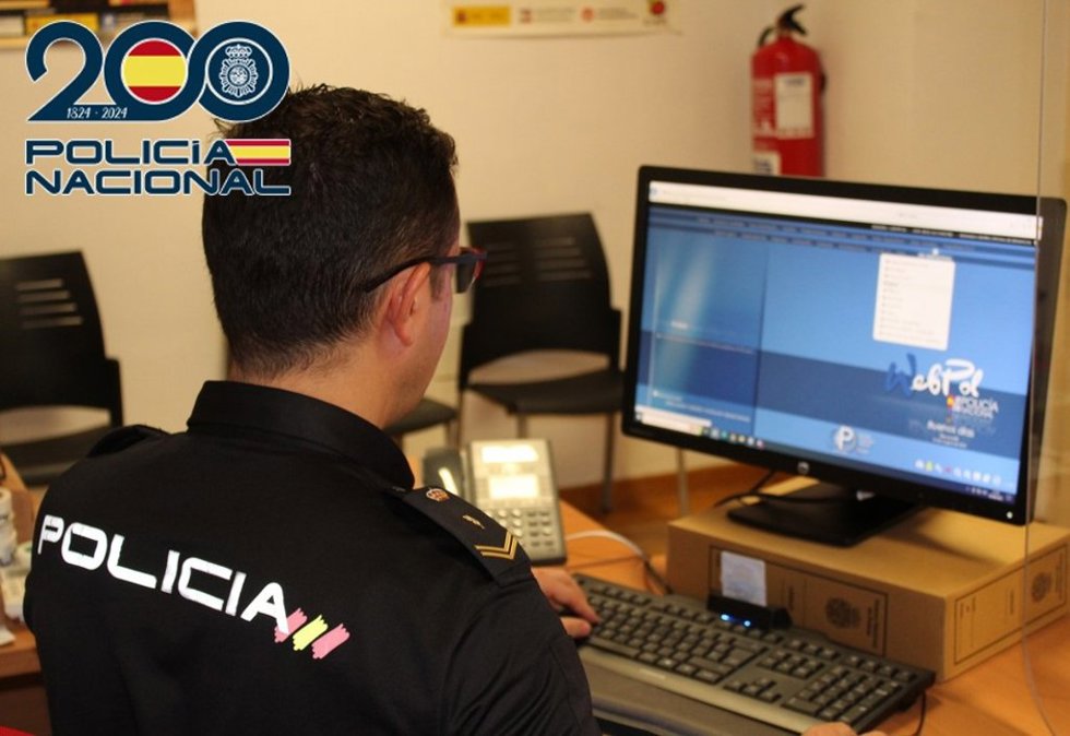 Agente de la Policía Nacional junto a un ordenador.