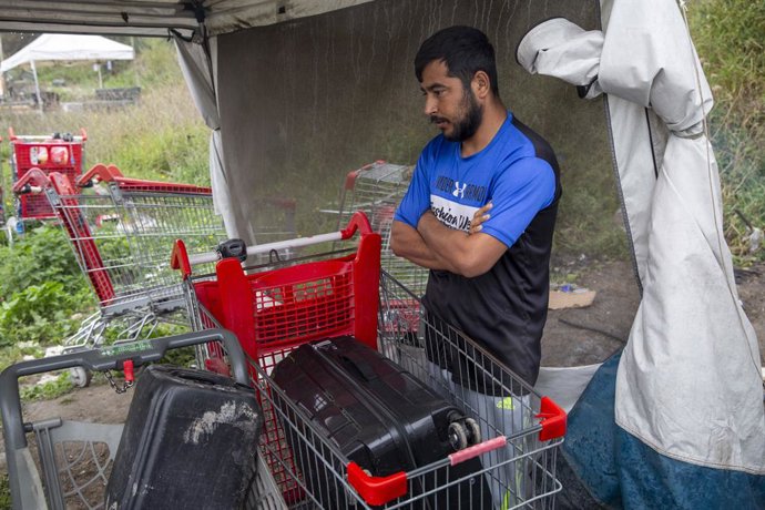 Archivo - Arquivo - 19 de setembro de 2023, DUNKIRK, Maisons-Laffitte, FRANÇA: Um migrante se protege da chuva em um acampamento de migrantes, em 19 de setembro de 2023, na cidade de Dunkerque, no norte da França. Os migrantes que tentam deixar a França r