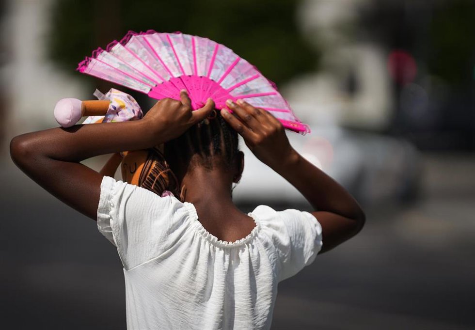 Una niña se protege el sol con un abanico. ARCHIVO. 