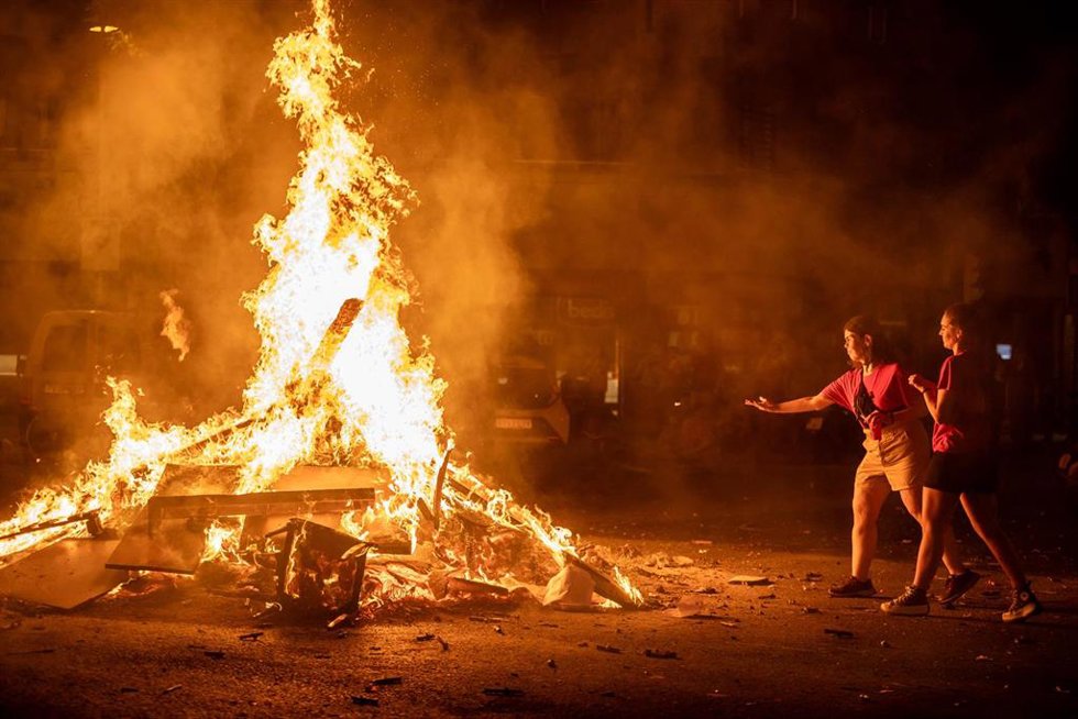 Archivo - Dos mujeres tiran los deseos a la hoguera del barrio de Sant Antoni  durante la noche de San Juan, a 23 de junio de 2023, en Barcelona, Catalunya (España)