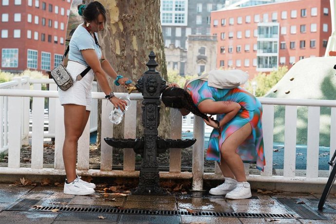 Archivo - Una mujer bebe agua de una fuente durante ola de calor en Bilbao, Vizcaya, País Vasco (España). Imagen de archivo.