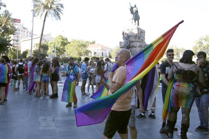Archivo - Un hombre levanta una bandera durante una manifestación por el Orgullo LGTBIQ+ en Palma.