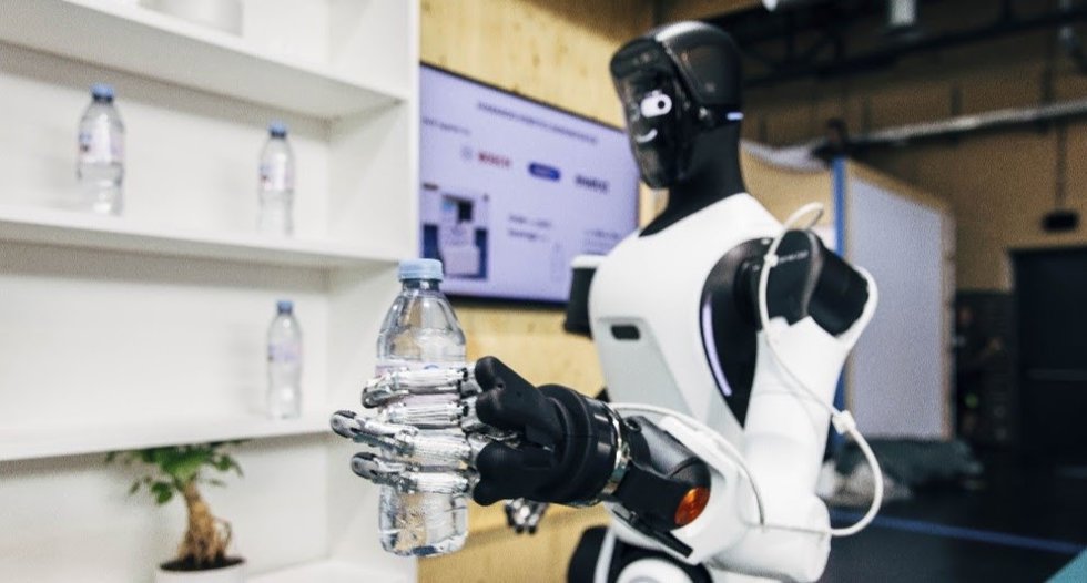 Robot humanoide sostiene en su mano una botella de plástico
