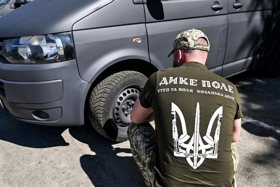 Un militar revisa las ruedas de un minibús perteneciente a un lote de 14 vehículos entregados a ocho unidades militares ucranianas que operan en el sector de Zaporizhzhia.