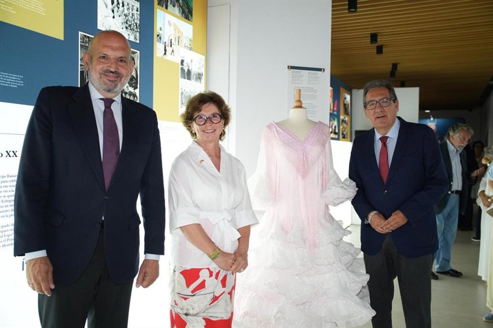 El delegado de Fiestas Mayores, la embajadora de Mónaco y el presidente de la Diputación, junto a la recreación del traje de flamenca de la princesa Grace