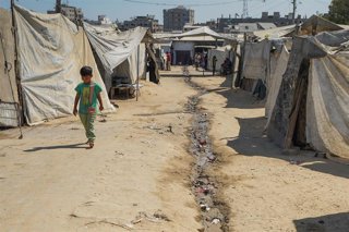 Los palestinos desplazados viven en condiciones precarias junto a montones de basura acumulada en el campo de refugiados de Bureij.