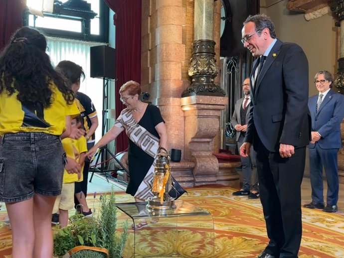 El presidente del Parlament, Josep Rull, recibe la Flama del Canigó de manos de un grupo de niños de Corbera de Llobregat (Barcelona)