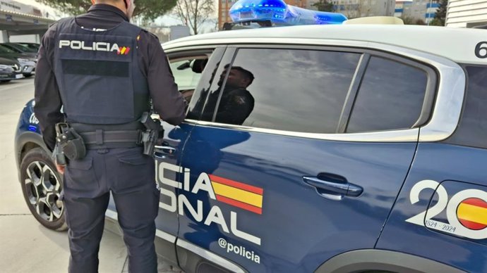Archivo - Un agente de la Policía Nacional de Valladolid ante su coche patrulla. Foto de archivo