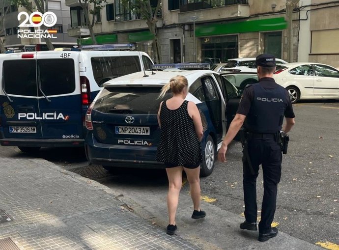 La mujer detenida, escoltada por un agente de la Policía Nacional.
