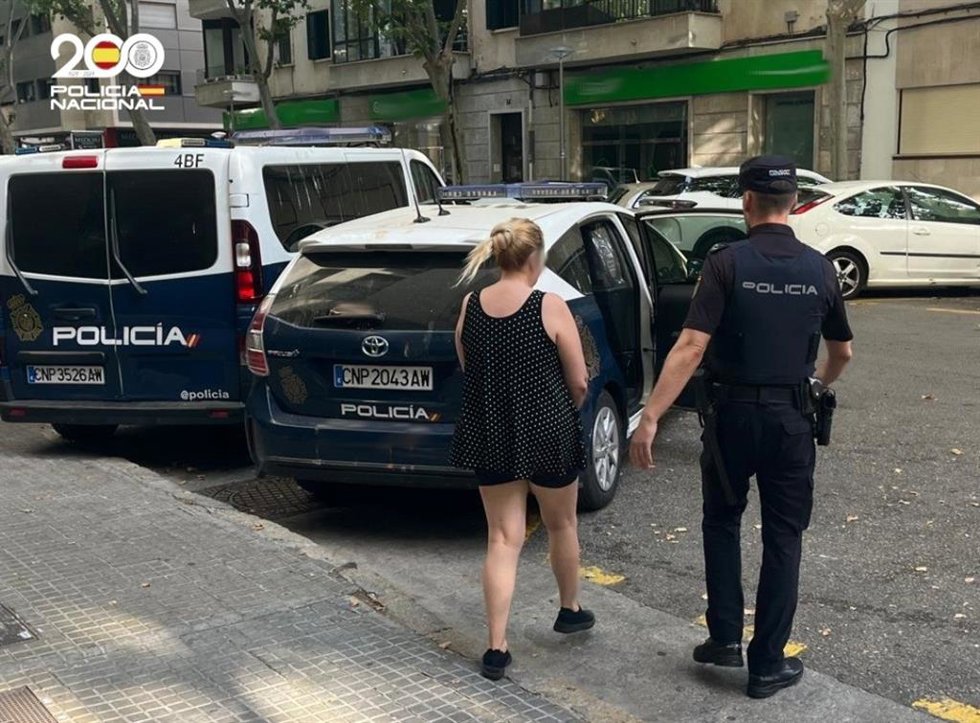 La mujer detenida, escoltada por un agente de la Policía Nacional.