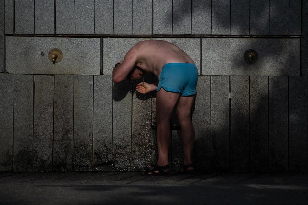 Una persona se refresca en una fuente. Archivo.