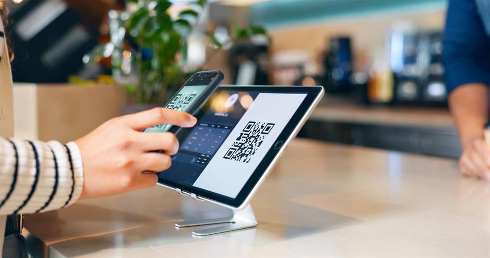 Archivo - Teléfono móvil escanenado un código QR