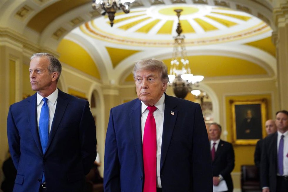 Donald Trump camina junto al líder de la mayoría republicana en el Senado, John Thune