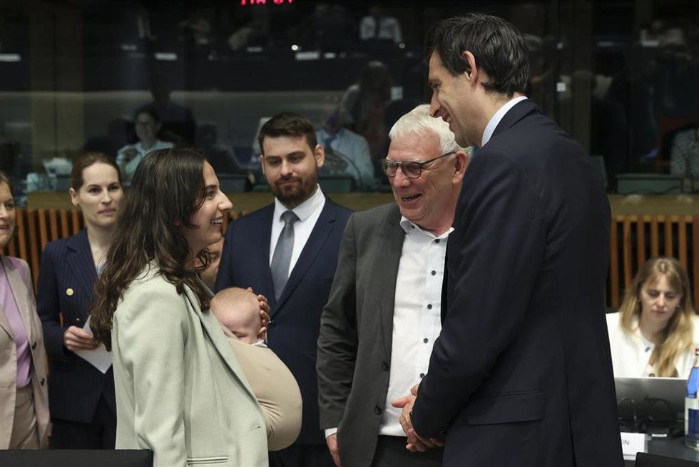 La ministra sueca de Medio Ambiente, Romina Pourmokhtari, porta a su bebé durante una reunión de ministros de la UE en Luxemburgo, mientras charla con el comisario de Clima, Wopke Hoekstra, y otros ministros.