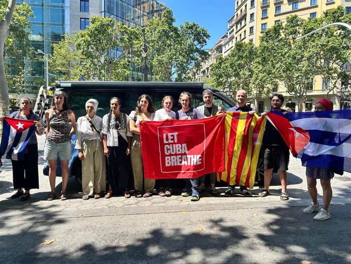 Representantes de ERC, Comuns, CUP e Izquierda Europea junto al convoy de la campaña 'Europa, wake up! Let Cuba breathe' en Barcelona