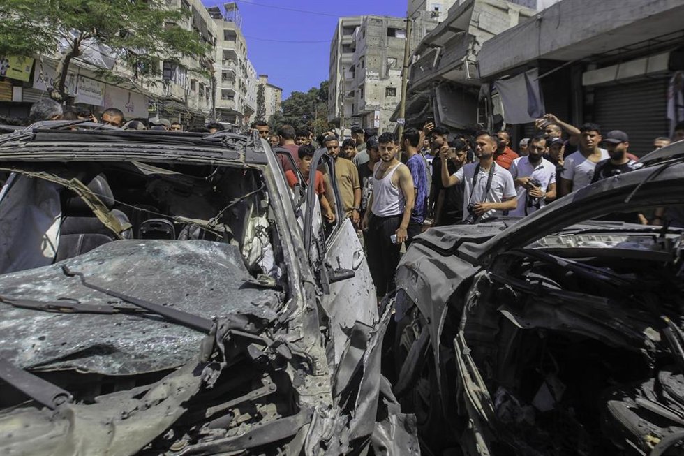 Palestinos inspeccionan dos vehículos alcanzados por un bombardeo de Israel contra Rimal, en la ciudad de Gaza, a pesar del alto el fuego pactado en octubre de 2025 (archivo)