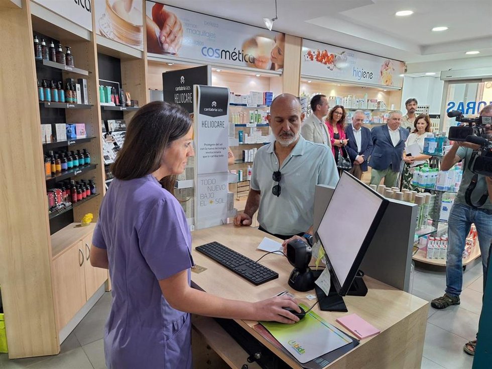 Una farmacéutica atiende a un usuario durante la presentación de la receta electrónica concertada de Muface en Almería.