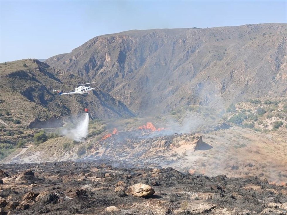 Un helicóptero del Plan Infoca realiza una descarga de agua durante los trabajos de extinción del incendio forestal declarado en Berja (Almería).