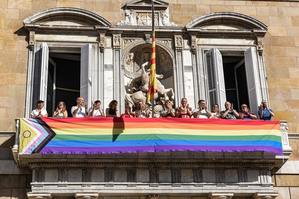 Menor y miembros de la Conselleria despliegan una bandera LGTBI+ en el balcón del Palau de la Generalitat por el 28J.