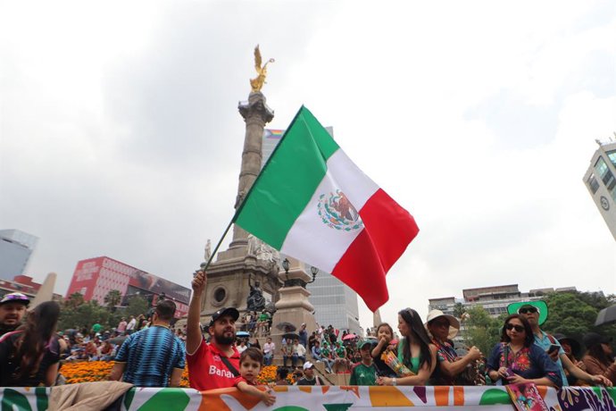 A person waves a Mexican national flag during ''The Ball Returns Home"  parade as part of 2026 FIFA World Cup on Paseo de la Reforma Avenue. on June 13, 2026 in Mexico City, Mexico.