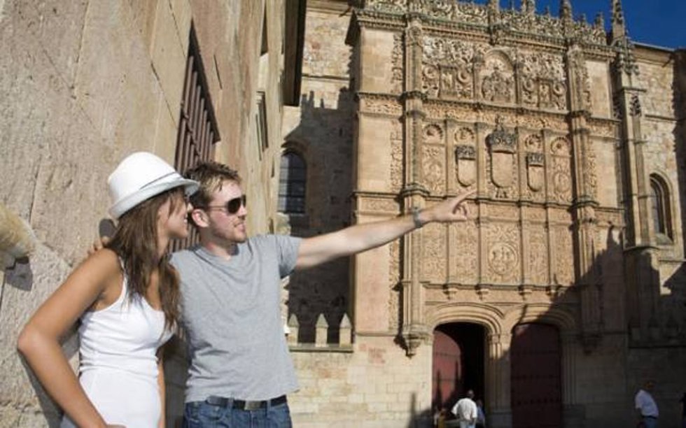 Archivo - Foto de archivo de unos turistas frente a la fachada de la Universidad de Salamanca
