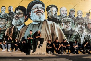 June 26, 2026, Beirut, Lebanon: Pro-Iranian Hezbollah supporters sit in front of a poster of party leaders assassinated by Israel in Beirut's southern suburb as they mourn during the last day of Ashura, which marks the 7th century martyrdom of Imam Hussei