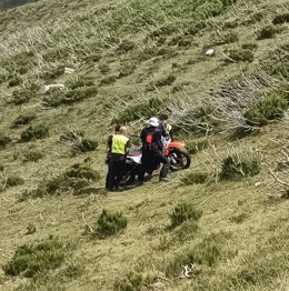 Bomberos ayudan a un motorista que se salió de una pista forestal por una ladera en Los Tejos, en Liébana