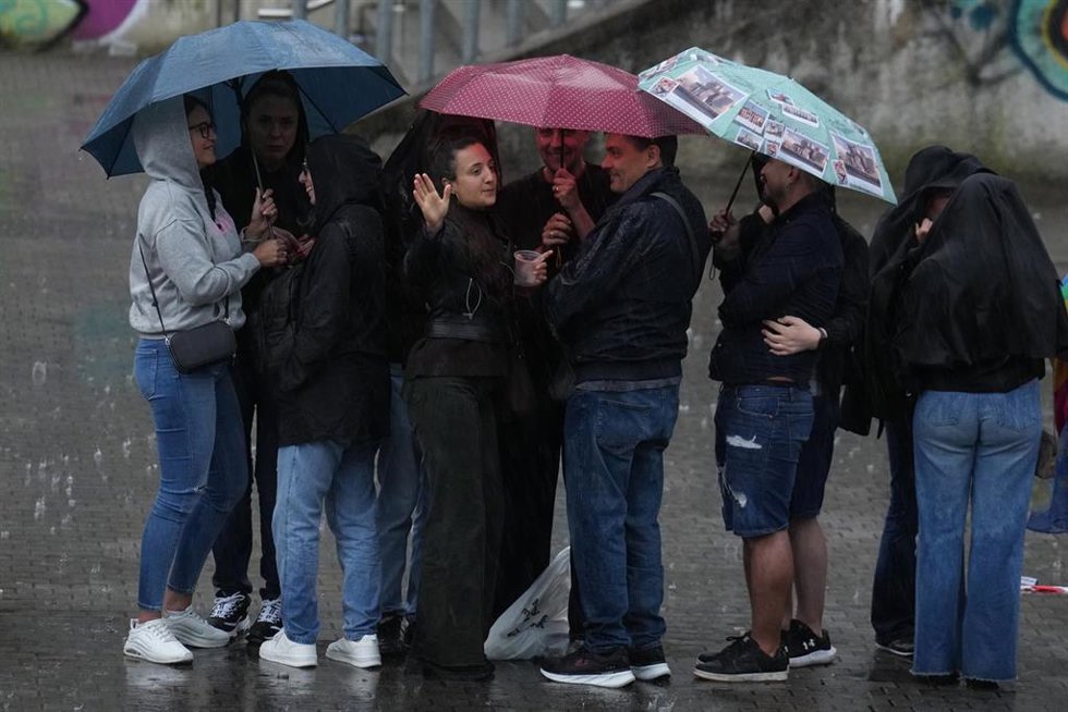 Archivo - Varias personas bajo la lluvia