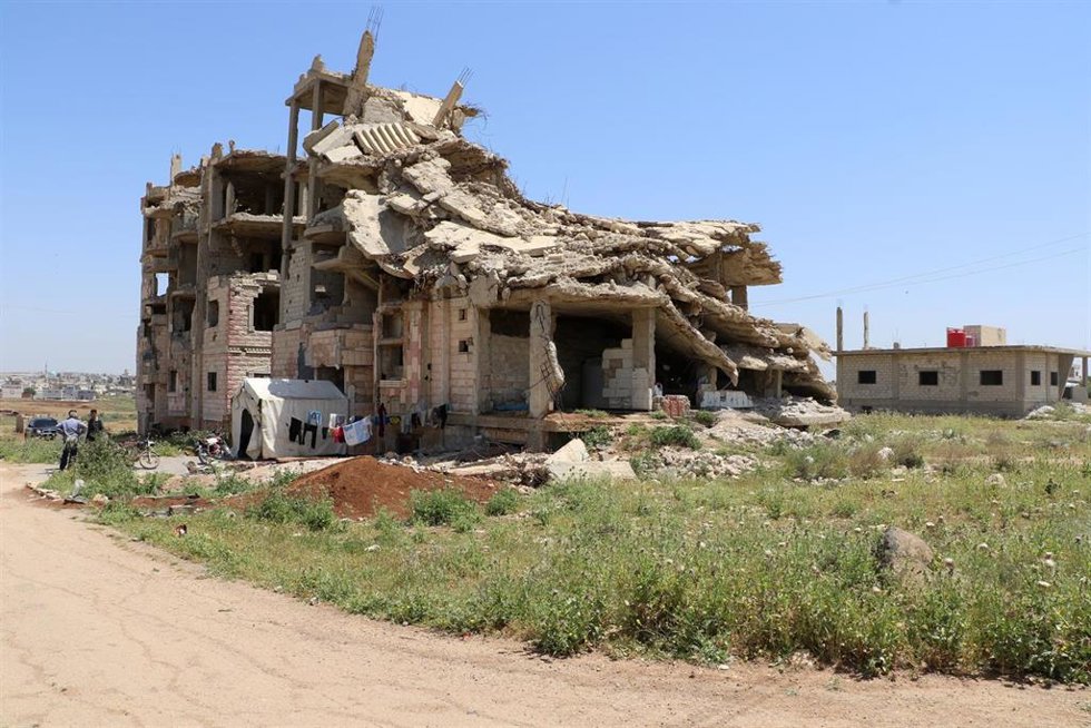 Archivo - Un edificio de apartamentos dañado que alberga a varias familias sirias desplazadas y retornadas en la provincia de Dará, Siria