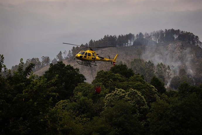 Helicóptero durante las labores de extinción de un incendio forestal, a 14 de junio de 2026, en Grado, Asturias (España). 