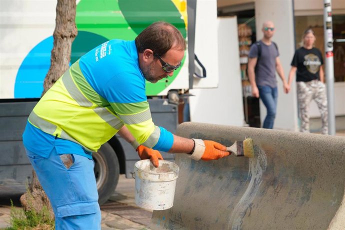 Archivo - Un operario de Emaya trata de borrar un grafiti en un banco de Playa de Palma.