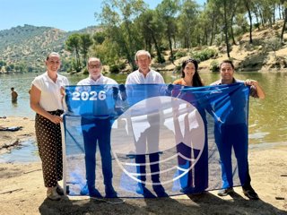 Responsables de la Junta y del Ayuntamiento de Andújar posan con la bandera azul en la playa de interior del Encinarejo.