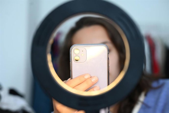 Archivo - Una joven se hace una fotografía con su teléfono móvil