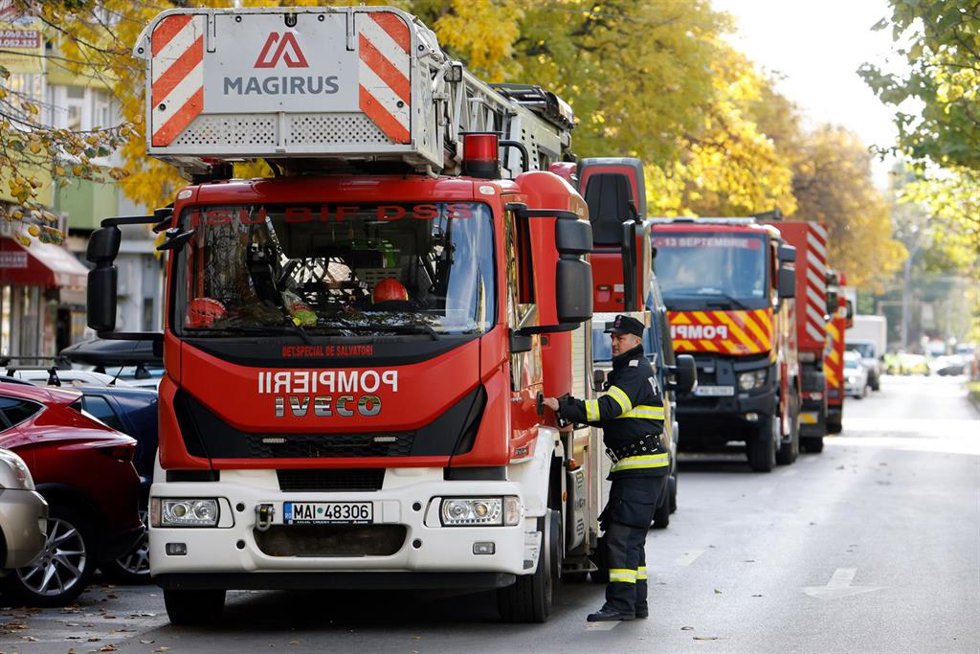 Archivo - Un bombero se dirige hacia un camión de bomberos en una calle de la zona acordonada, cerca de un edificio residencial afectado por una explosión en Bucarest el pasado octubre.