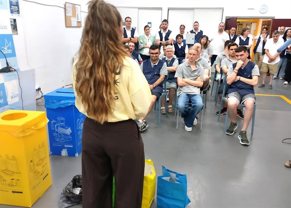 Una monitora explica el correcto recicleja a trabajadores con discapacidad intelectual en el Taller Usoa de Barakaldo