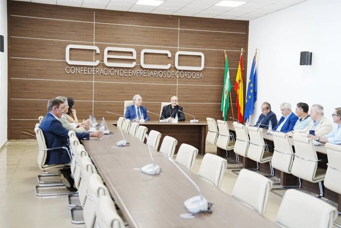 El obispo (al fondo), junto al presidente de CECO, durante su encuentro con el Comité Ejecutivo de la patronal cordobesa.