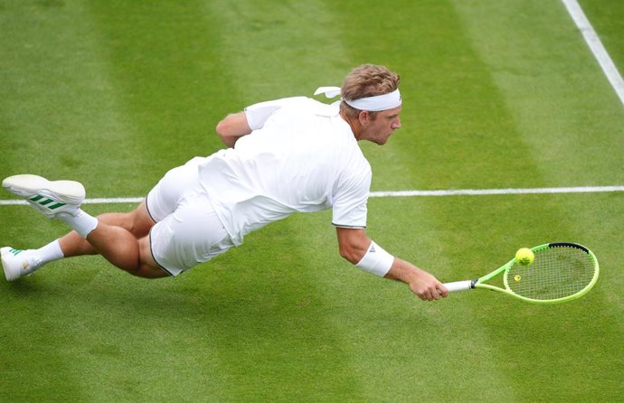 01 July 2026, United Kingdom, London: Spanish tennis player Alejandro Davidovich Fokina falls while attempting to return the ball to Hungary's Fabian Marozsan during their Men's Singles second-round match on Day Three of the 2026 Wimbledon Championships a
