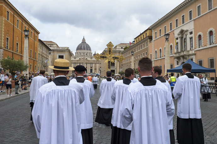 Sacerdotes portan la cruz procesional en dirección a la Basílica de San Pedro durante la peregrinación de la Fraternidad Sacerdotal San Pío X 