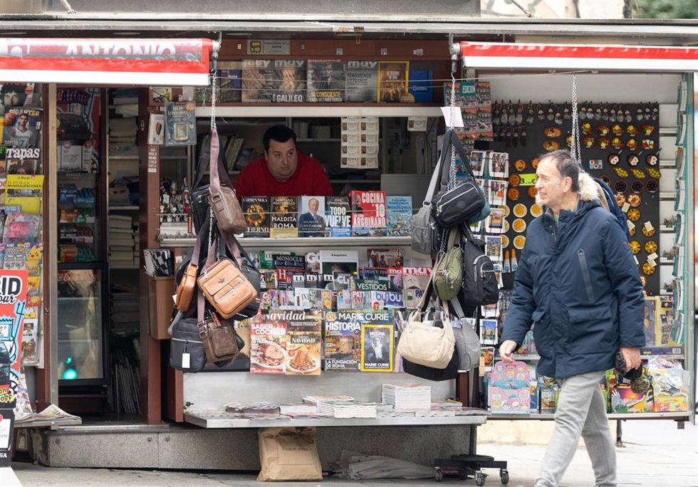 Archivo - Un hombre camina junto a un quiosco, a 15 de diciembre de 2023, en Madrid (España). 