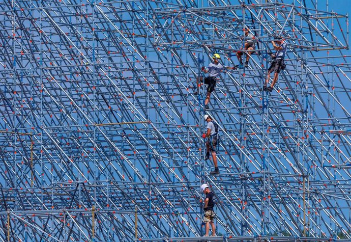 Trabajadores montando un escenario para un evento musical.