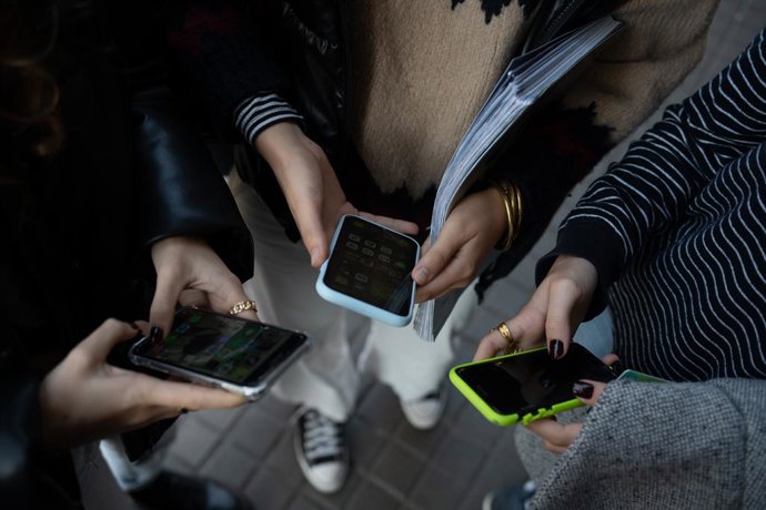 Archivo - Varias personas usan el teléfono móvil, a 1 de febrero de 2024, en Barcelona, Catalunya (España). El pasado 30 de enero el Govern aprobó las instrucciones que regulan el uso de los dispositivos móviles en las aulas de colegios e institutos, que 