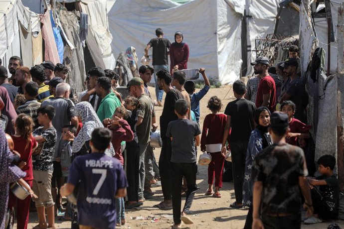 2 de julho de 2026, Cidade de Gaza, Faixa de Gaza, Território Palestino: Palestinos deslocados, incluindo mulheres e crianças, se reúnem para receber refeições em um ponto de distribuição de alimentos de uma instituição de caridade a leste da Cidade de Ga