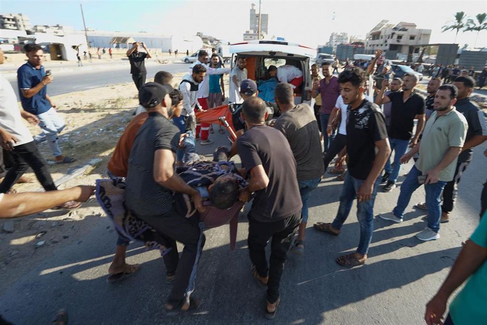 Un grupo de palestinos socorren a las víctimas de un ataque israelí contra el centro de la Franja de Gaza