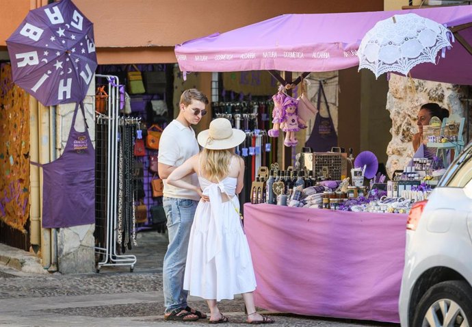 Archivo - Dos personas observan un puesto de productos de lavanda en Brihuega, una de los localidades declarada 'Municipio Turístico'.