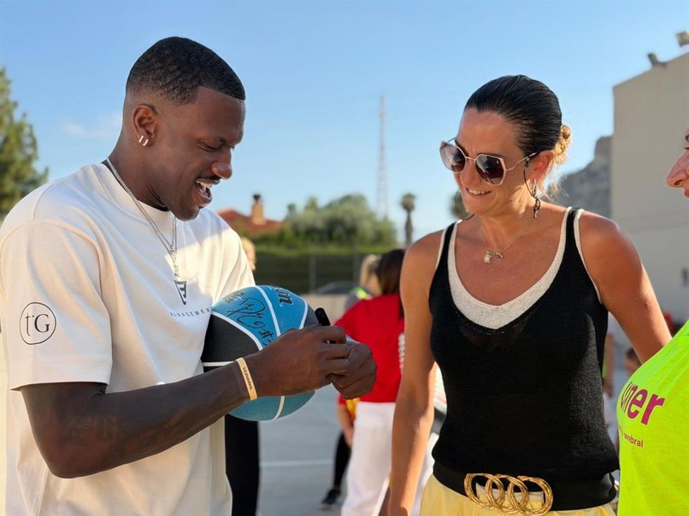 Dylan Ennis firma un balón a la alcaldesa de Archena en su visita a la Escuela Inclusiva